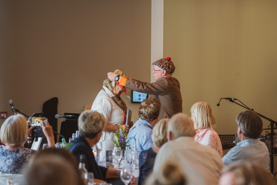 Standup-komiker Pilten overrekker medalje til Marianne Smith Magelie.